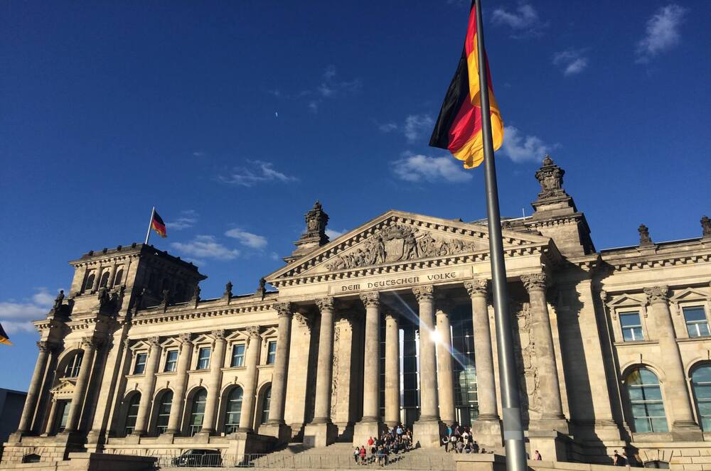 Reichstag building and German flag in Berlin – moving from the UK to Berlin