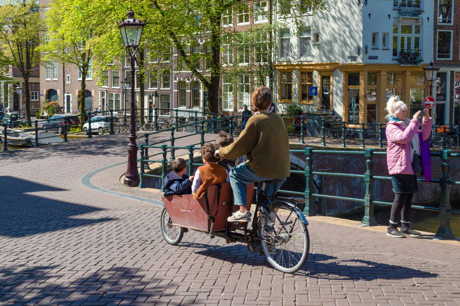 Cyclist crossing a canal bridge in Amsterdam – moving from the UK to Amsterdam