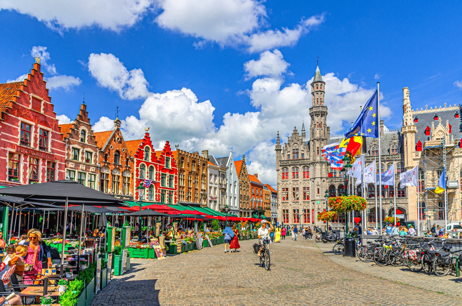 Colourful buildings and cafe terraces in Bruges' market square – moving from the UK to Bruges