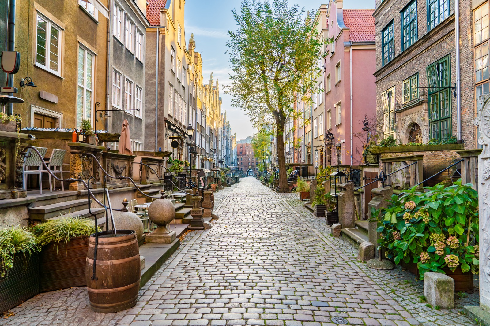 Cobbled lane with flower pots and historic buildings in Gdansk – part-load removals to Gdańsk