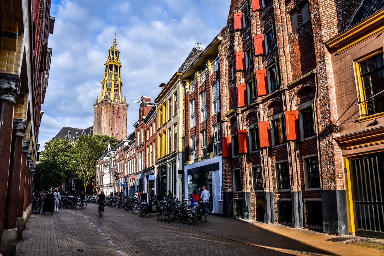 Bicycles lining a street leading towards a church tower in Groningen – shared-load removals to Groningen