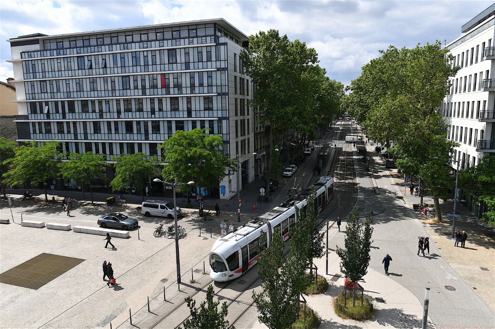 Tram and modern buildings on a tree-lined street in Lyon – shared-load removals to Lyon