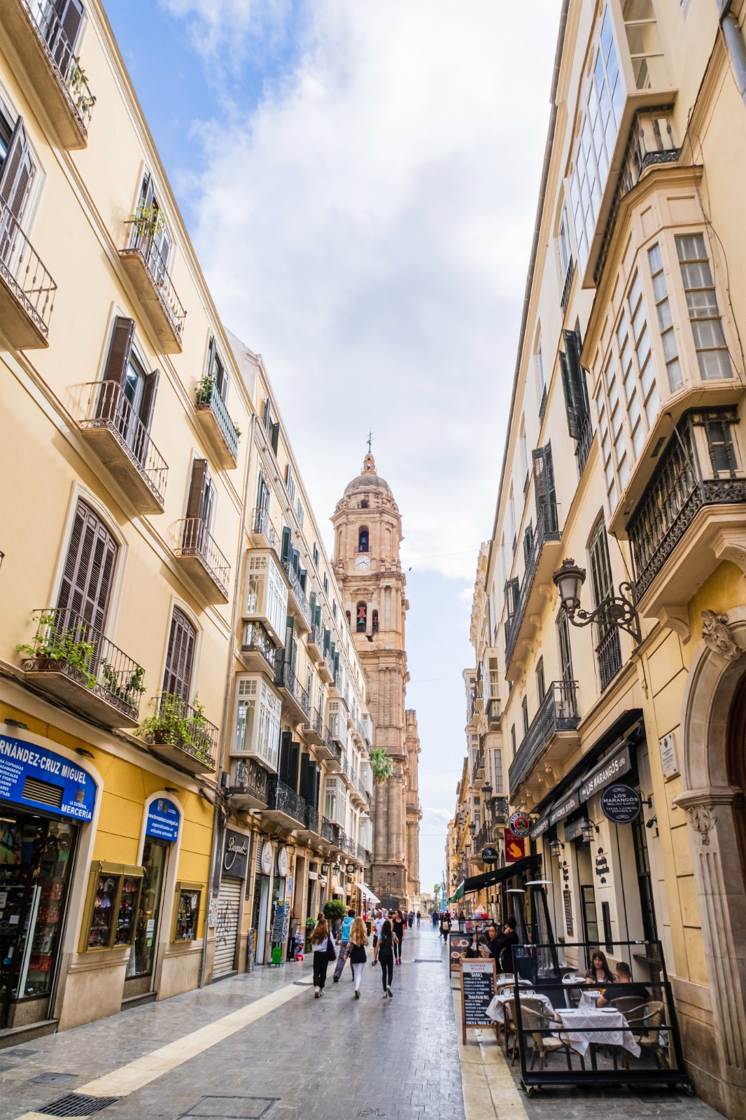 Pedestrian shopping street leading towards a church tower in Malaga – shared-load removals to Malaga