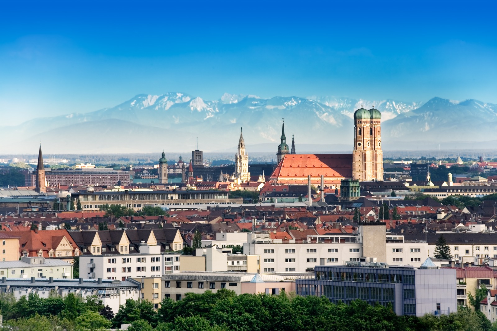 Munich skyline with the Frauenkirche towers and distant mountains – part-load removals to Munich