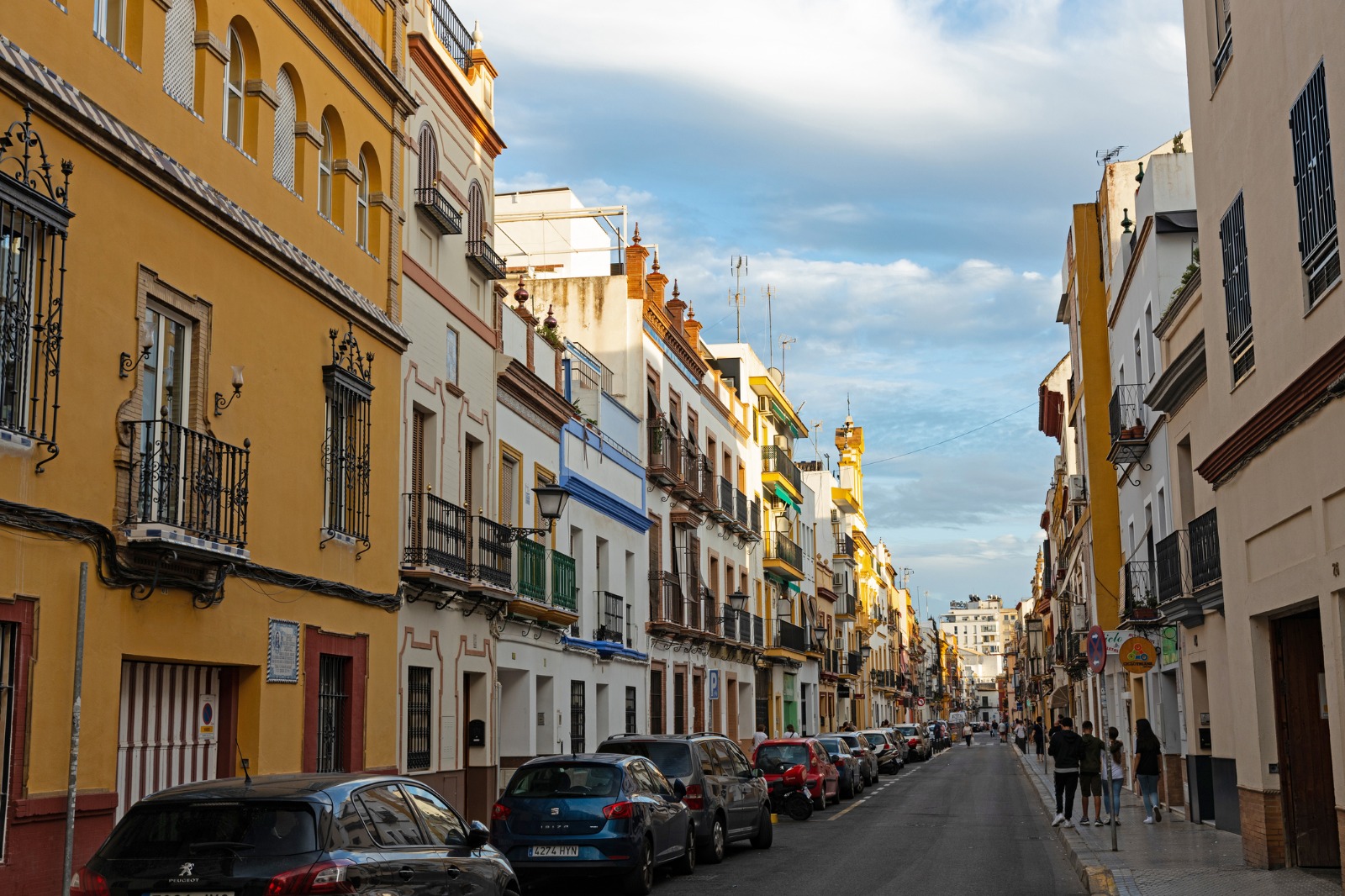 Parked cars and historic buildings along a street in Seville – removals from the UK to Seville