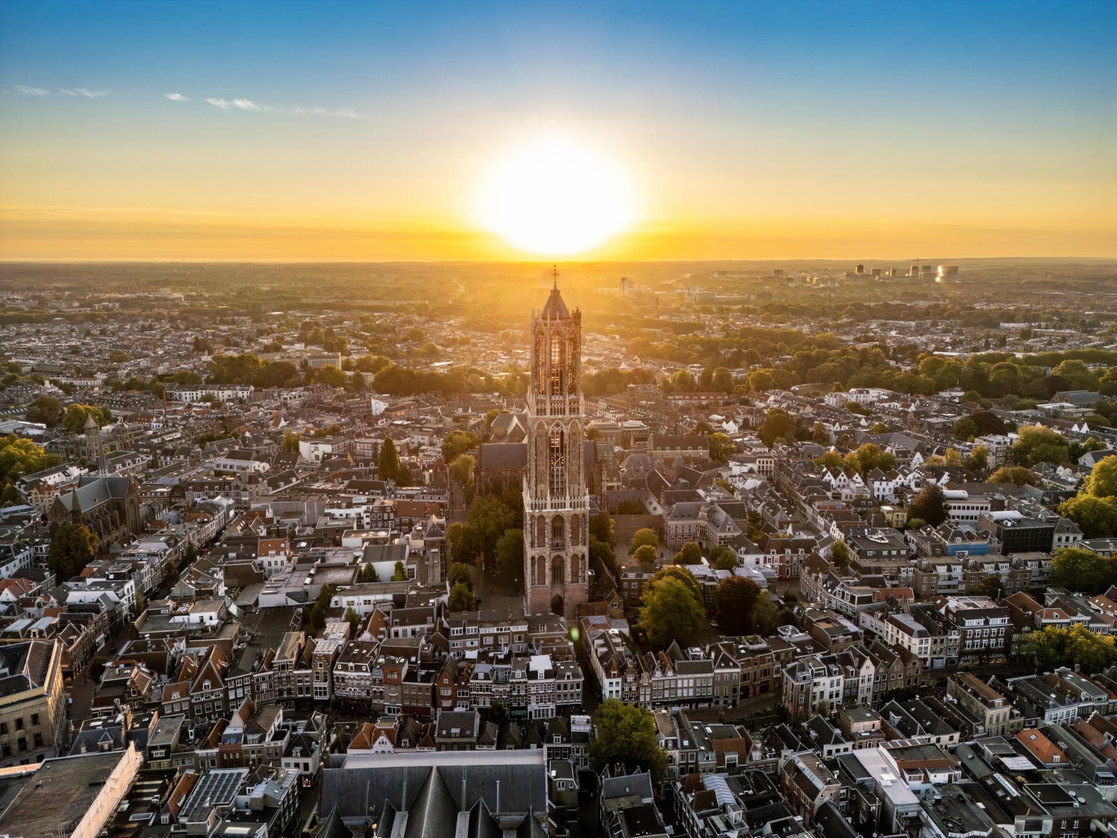 Dom Tower above the rooftops of Utrecht at sunset – shared-load removals to Utrecht