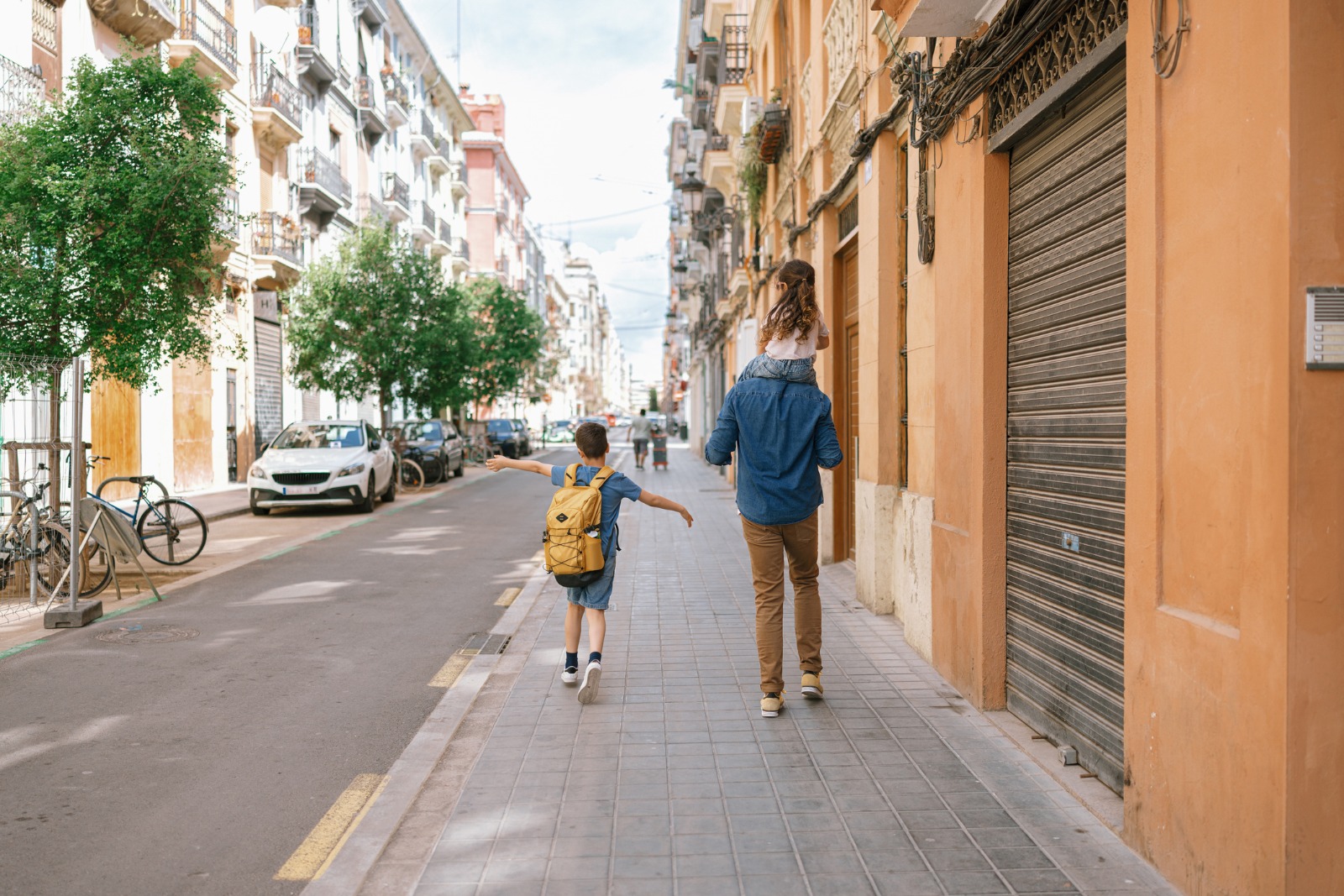 People walking beside apartment buildings on a street in Valencia – shared-load removals to Valencia