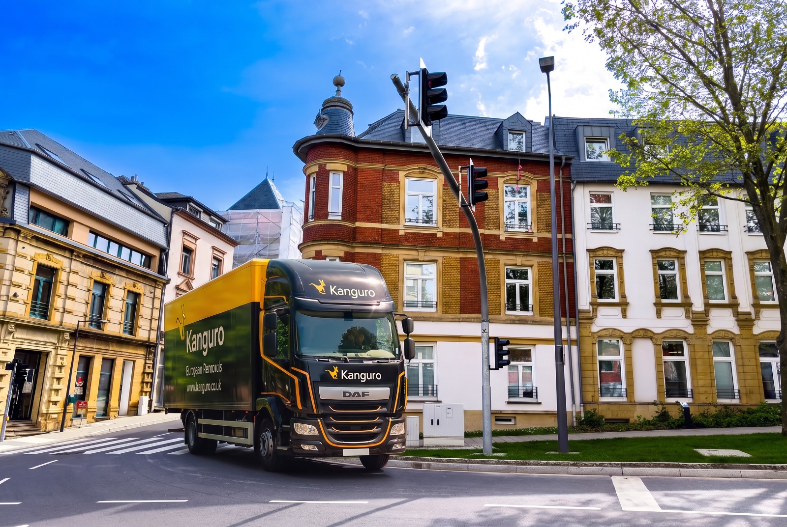 Kanguro removal truck beside an ornate corner building in Luxembourg – shared-load removals from the UK to Luxembourg