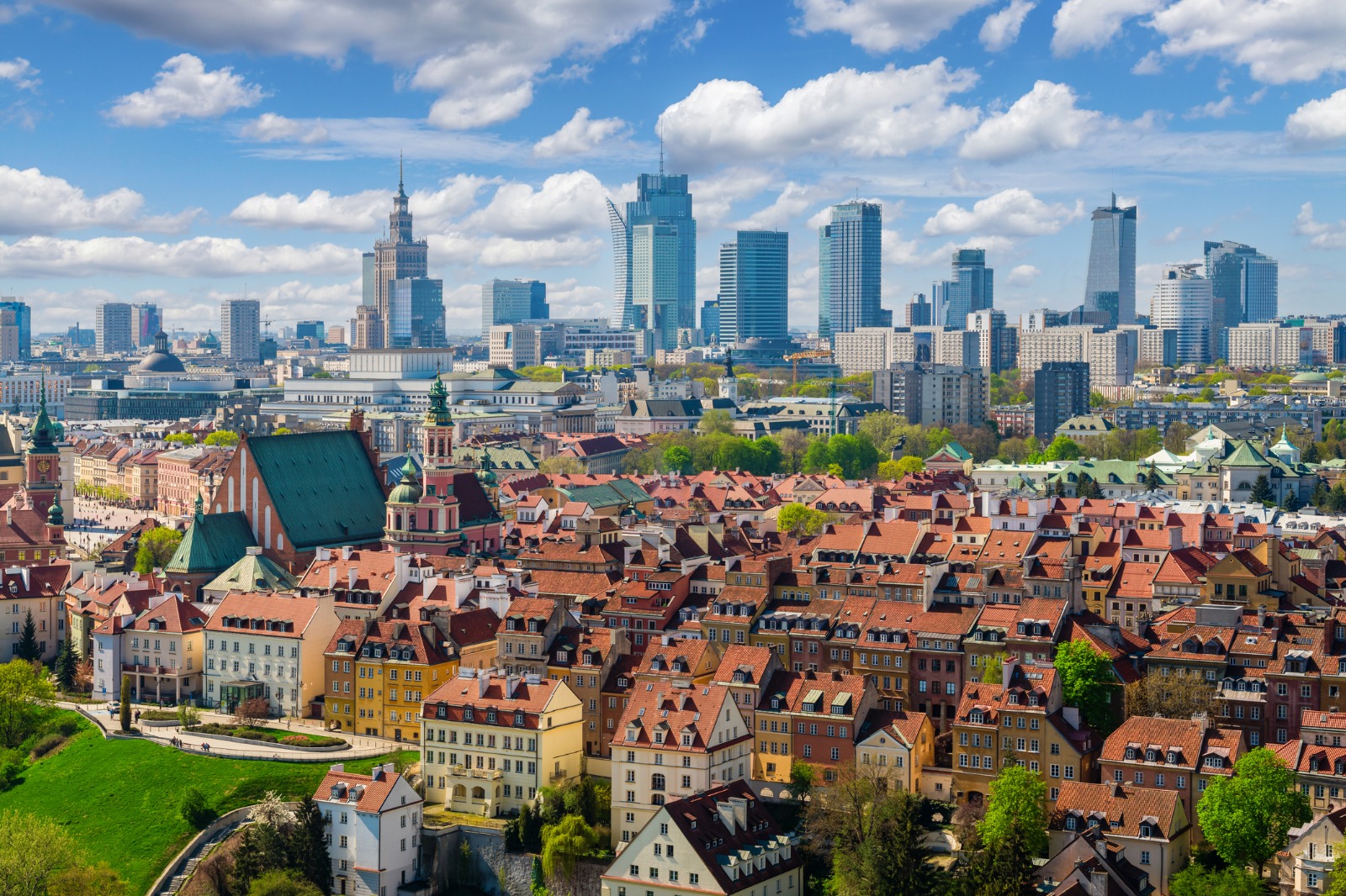 Warsaw's old town rooftops with modern towers in the distance – man and van removals from the UK to Poland